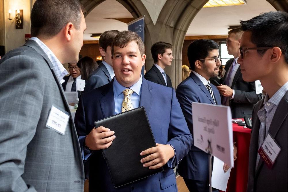 A Fox student converses with representatives of a local company.